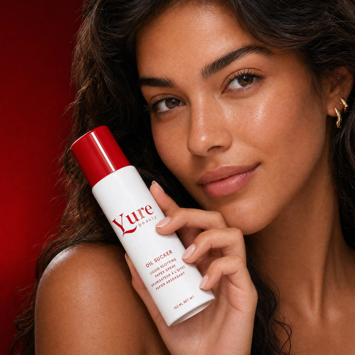 Close-up of a model holding the Glass Reset Mist bottle near her face